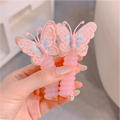Two pink and yellow butterfly charm hair ties on a white background